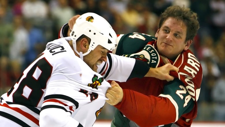 Two men's hockey players fight during a game.