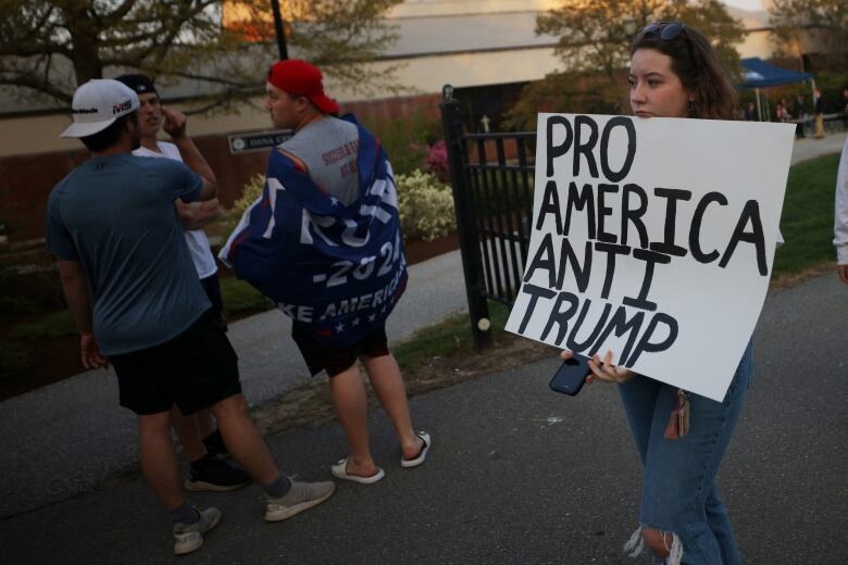 A woman holds a protest sign