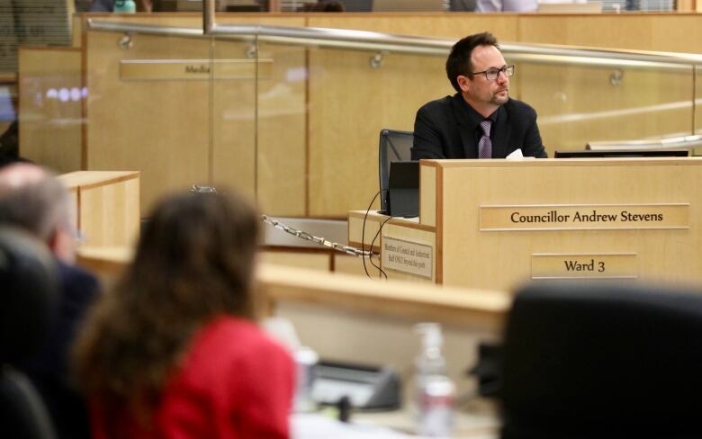 Regina Ward 3 Coun. Andrew Stevens sits in a city council meeting. City manager Niki Anderson can be seen in the foreground. 