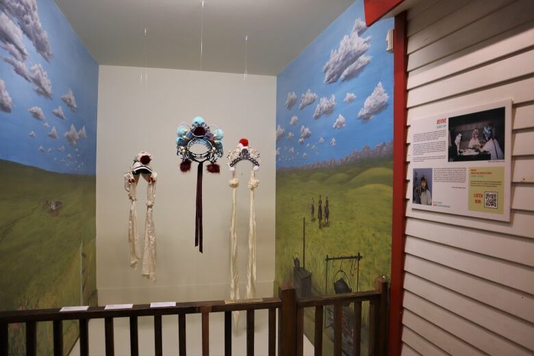 Headdresses hang in an exhibit.