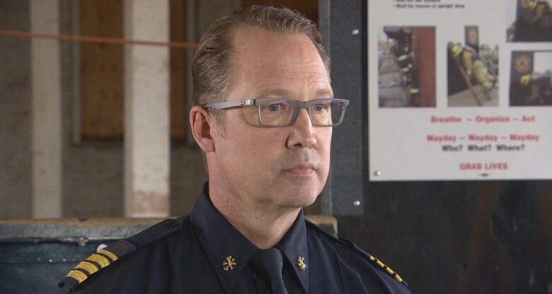 A man with glasses in uniform is photographed. 