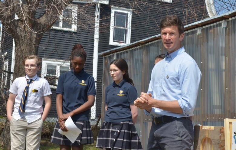 A teacher with a group of students standing in a field. 