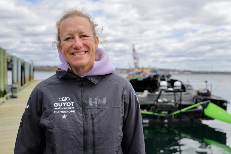 Annie Lush stands in front of her team's sailboat docked in the Halifax Harbour.