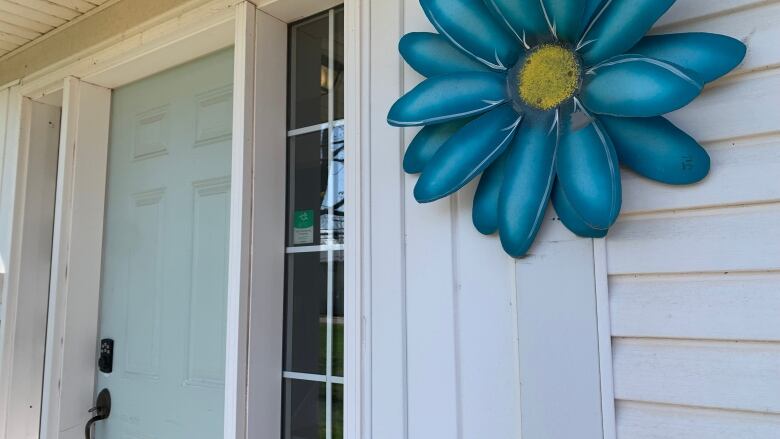 door at Blooming House is shown, as well as a large decorative blue metal flower. 