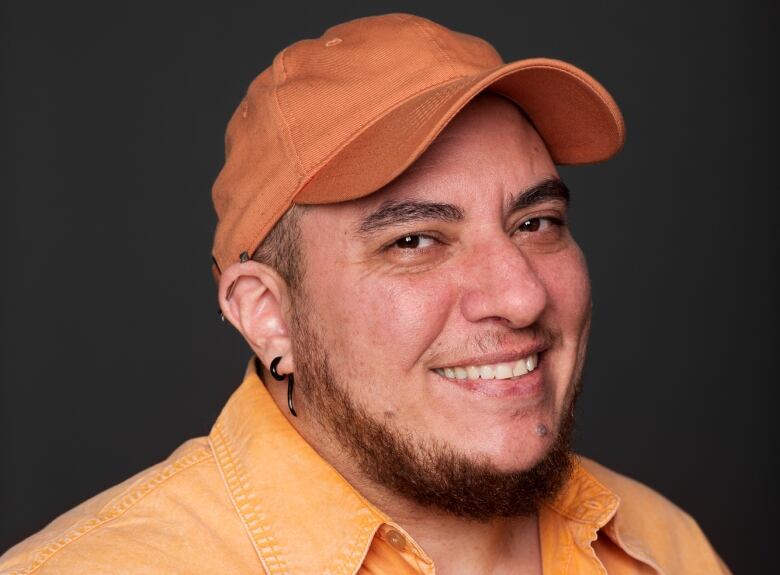 A person in a ball cap smiles for the camera in a headshot.