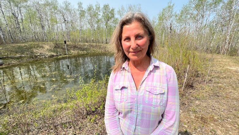 A woman standing in front of a slough.