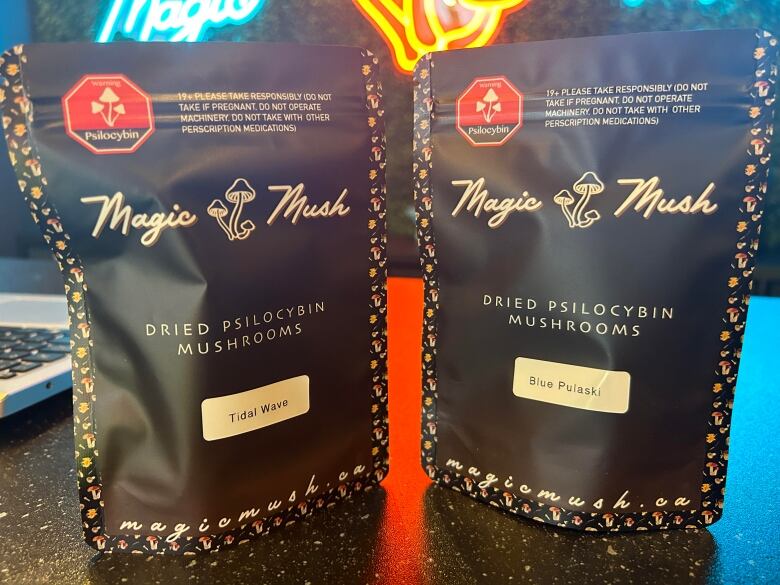 Two black pouches of magic mushrooms are displayed on a counter inside a magic mushroom dispensary.