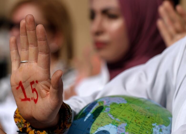 The palm of a protester is held up, with 1.5 written on it in red paint. 