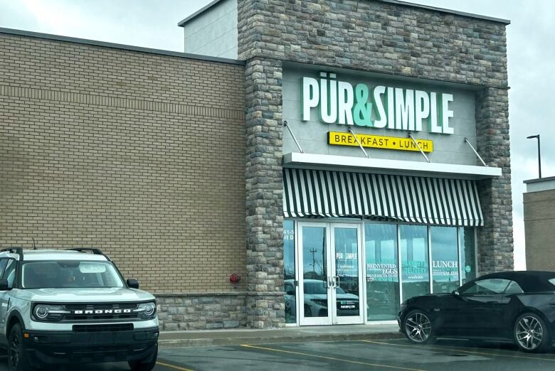 A brick building with a sign that reads Pur and Simple. 