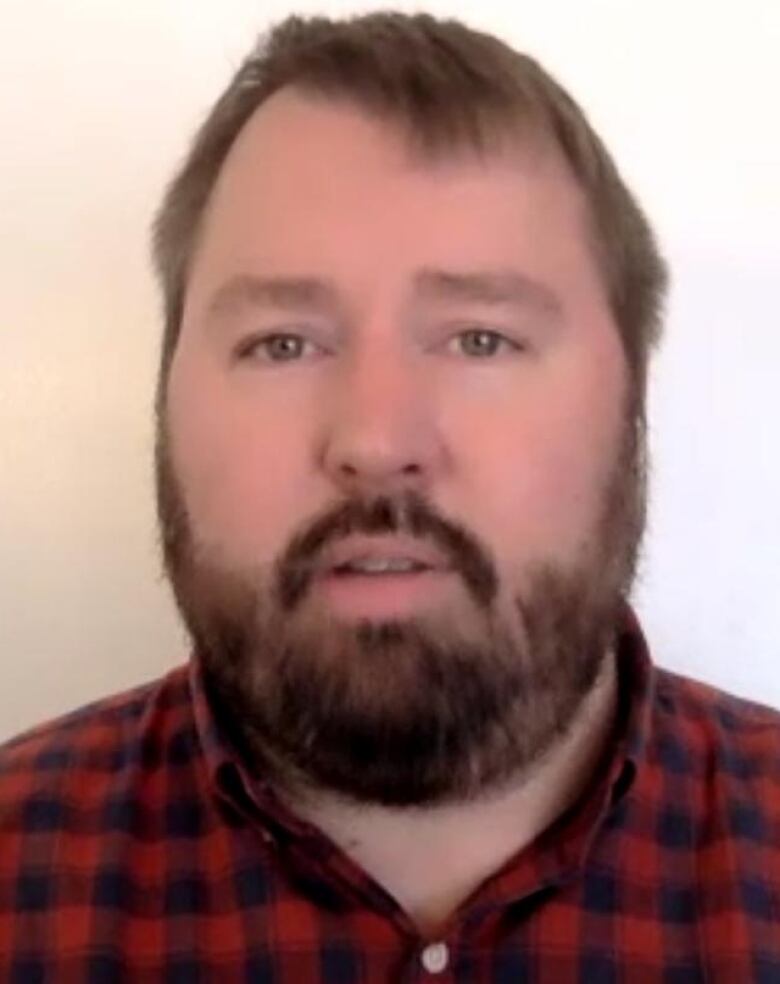 Chris Gallaway has a beard and is wearing a red checkered shirt. He's looking directly into the camera.