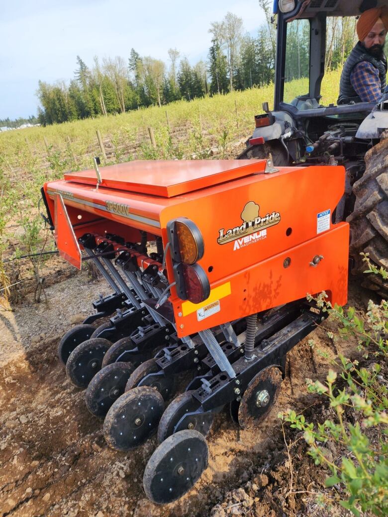 A farmer is pictured running his farm equipment.