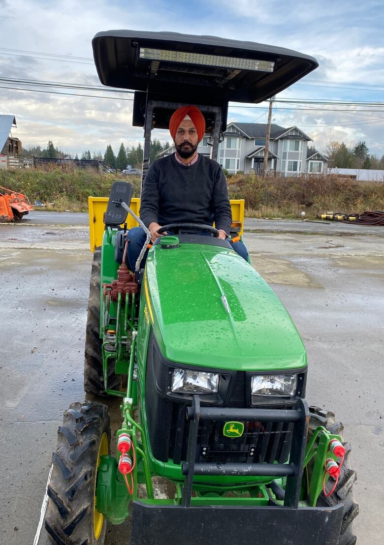 A farmer is pictured mounted on his farming equipment.