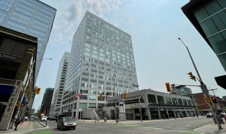 A downtown intersection with a large white and glass tower.