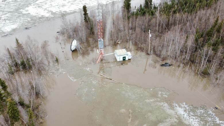 A satellite and transmitter booth in high murky water along a river.