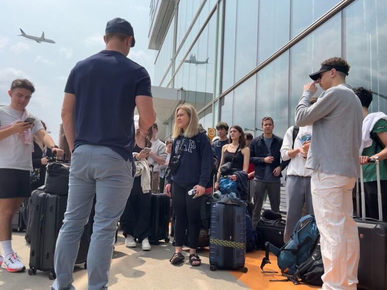 people standing outside Trudeau airport with luggage