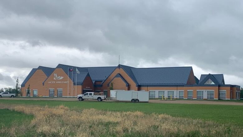 A building is seen in cloudy weather with a truck out front.