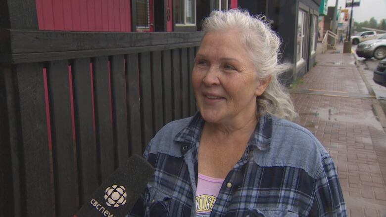 A woman speaks to CBC on a sidewalk.