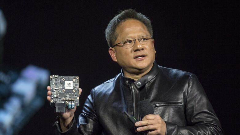 Jensen Huang, CEO of microchip maker NVidia, holds up one of the company's products.