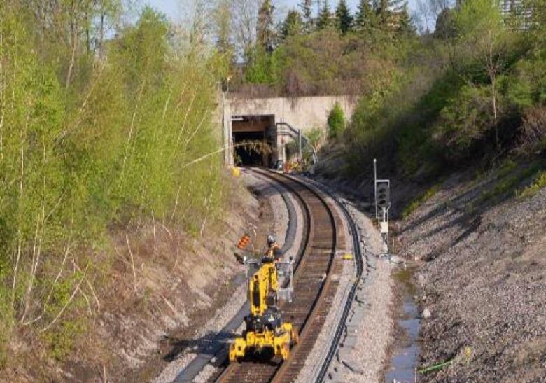 A yellow lift on train tracks