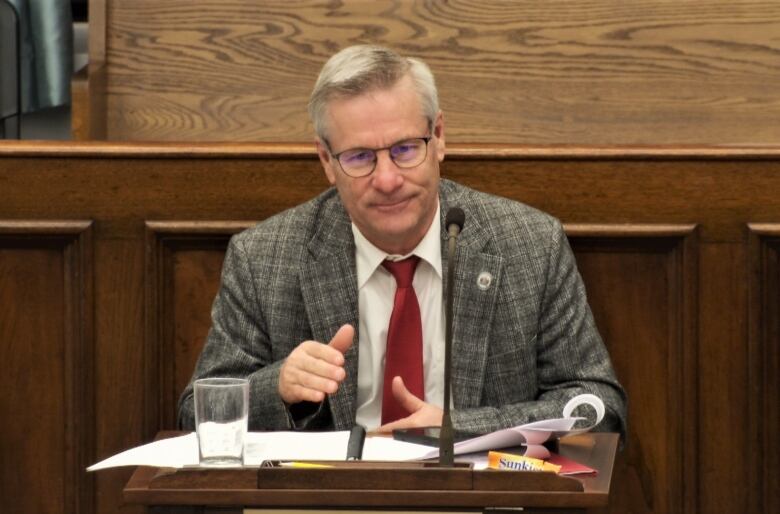 Robert Henderson seated at his desk in the legislature