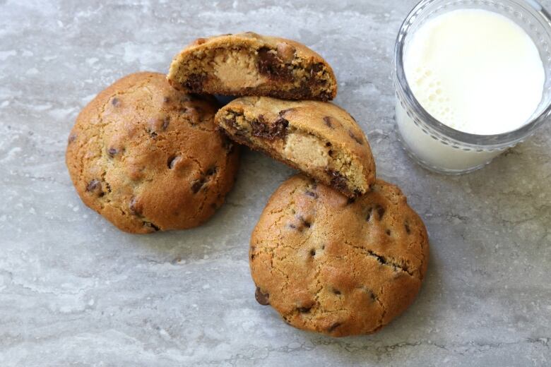 Stuffed chocolate chip cookie sit in a pile.