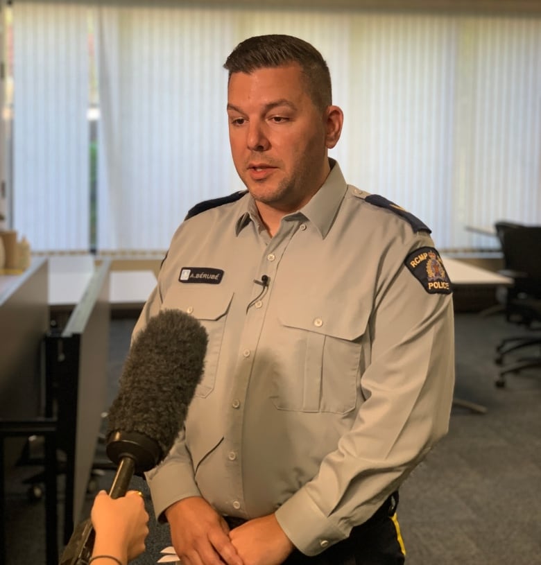 A police officer talks to a mic while in an office.