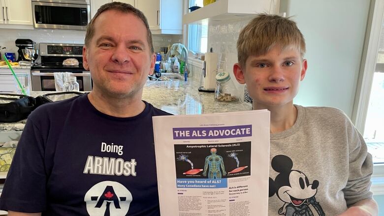 Father and son with ALS awareness paper