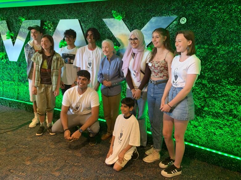 Jane Goodall stands in a group of smiling students.