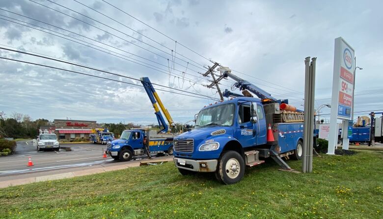 Two Maritime Electric trucks are positioned under a downed powerline on the day after the storm.