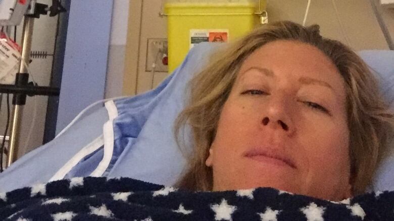 Becky Morrison is in a hospital bed. Above her head is a heart monitor and sign with her name on it.