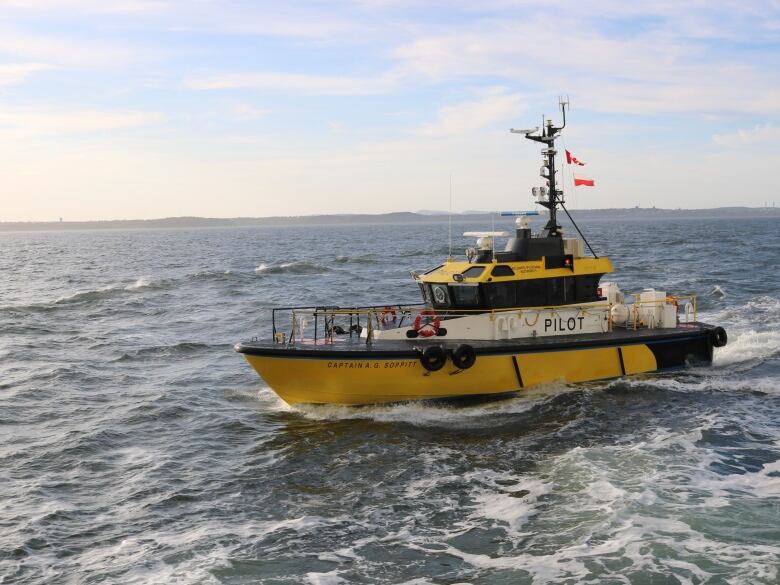 A yellow pilot boat on mildy choppy seas. 