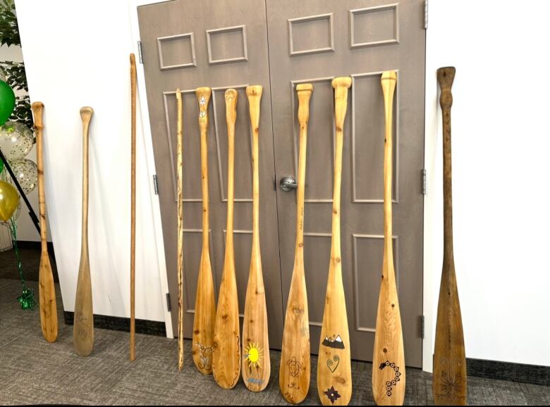 Paddles lean against a wall.