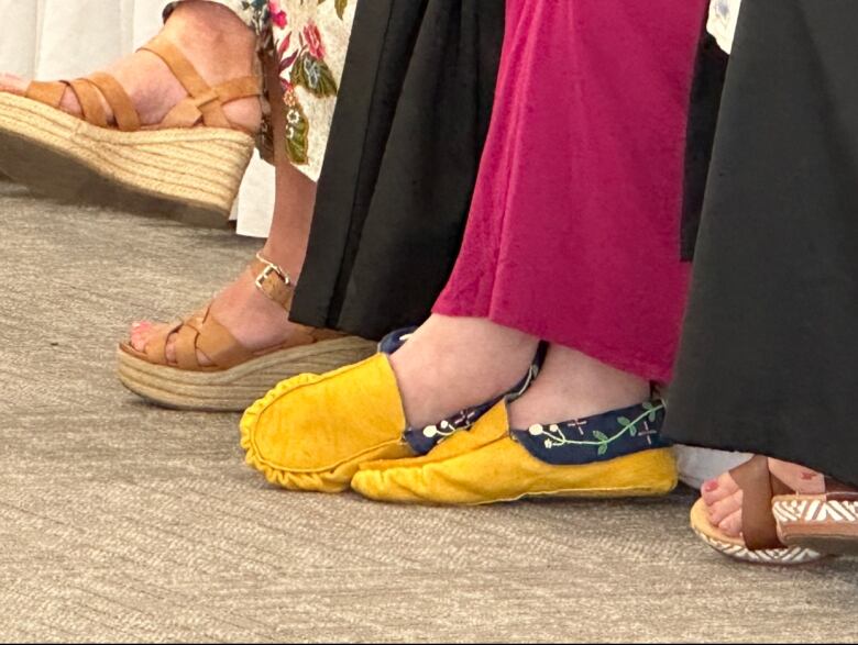 Yellow moccasins with embroidered flowers on the trimming.