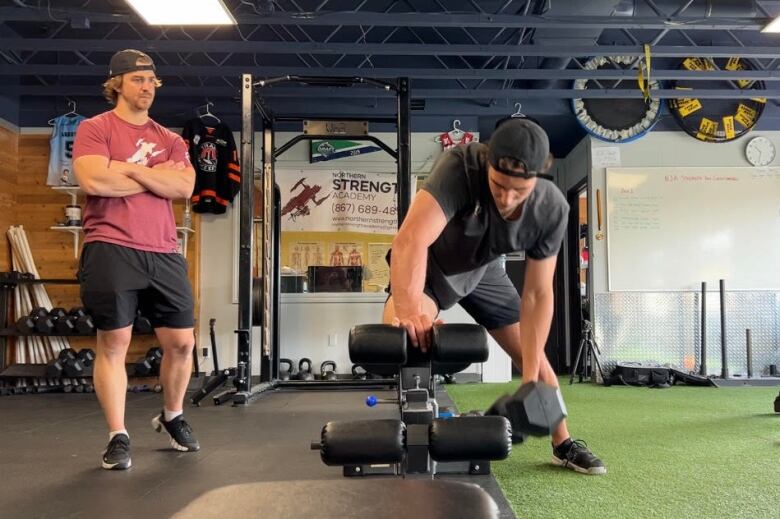 Man lifts weights in gym.