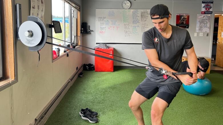 Man in gym performs excersize.