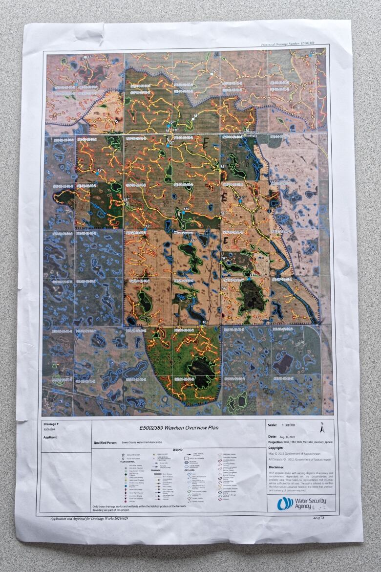 A colourful paper map with the drainage paths on it lays flat