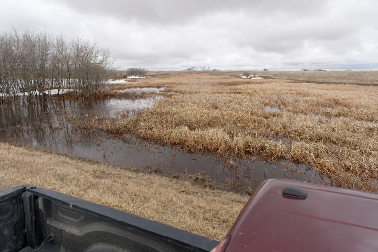 Looking down there is a red truck and then another drainage ditch