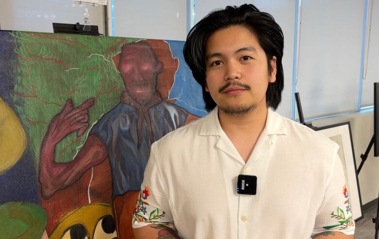 Ryle Ramirez is pictured stood next to one of his artworks. 