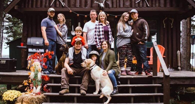 Three generations of a family pictured on the steps in front of a camp.