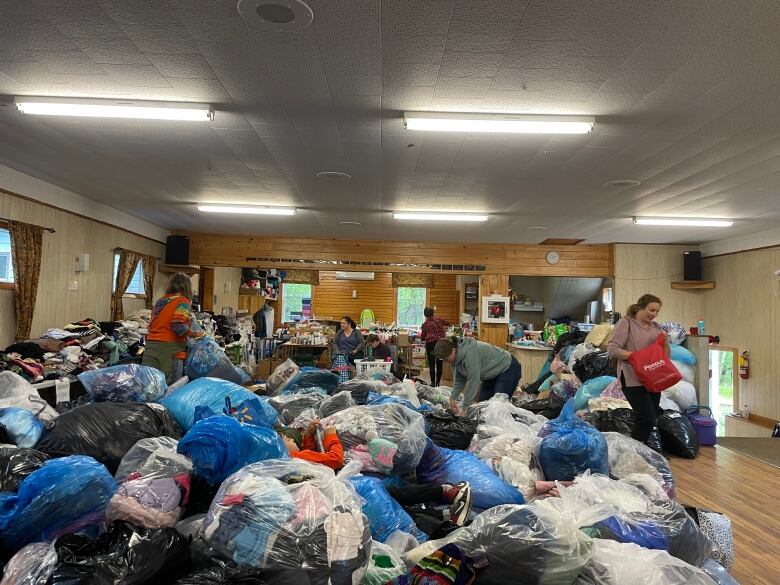 Dozens of garbage bags full of clothing are piling up inside a church. 