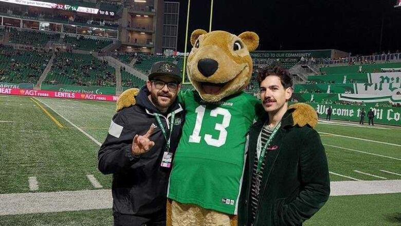 Two men pose with a gopher mascot.