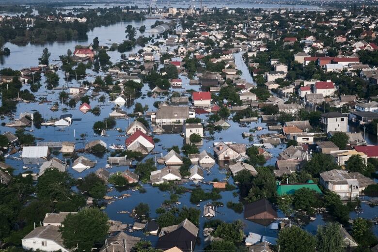 An aerial view of a town is shown with water levels rising