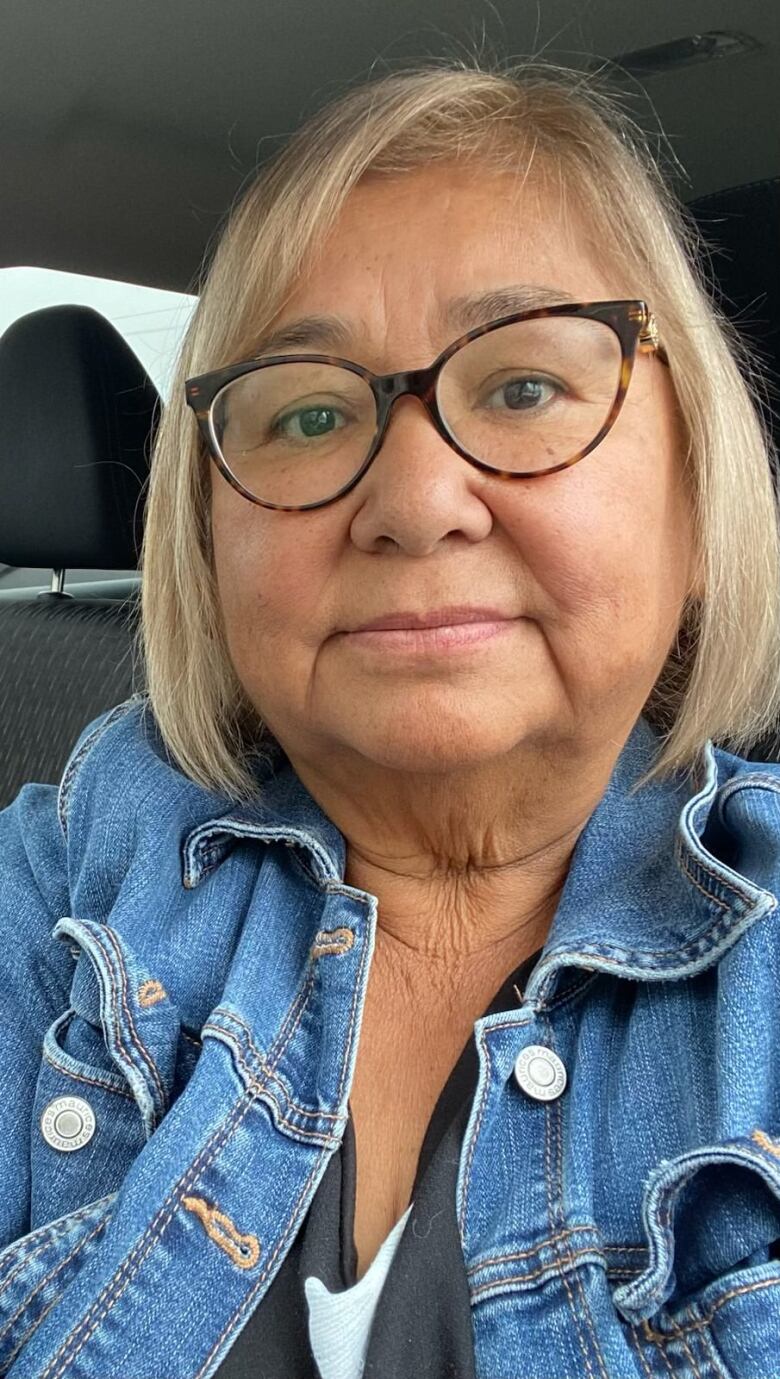 An Indigenous woman with blond hair and brown glasses. 