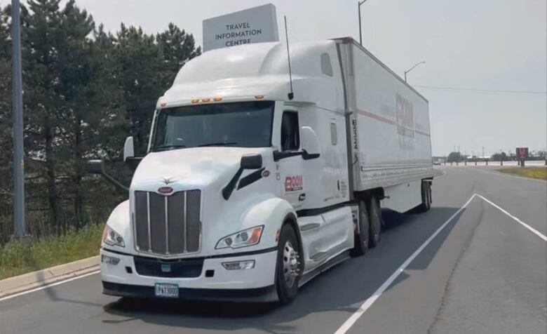 A large white transport truck driving on the road