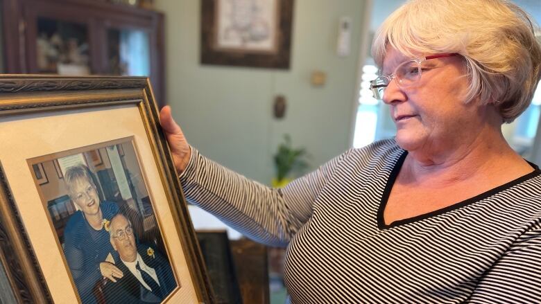 Brenda MacLean looks at a photo of herself and husband Lawrence. 