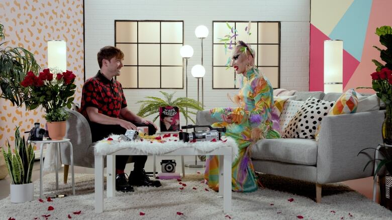 Here & Queer host Peter Knegt sits on the set with drag queen royalty Sasha Velour.