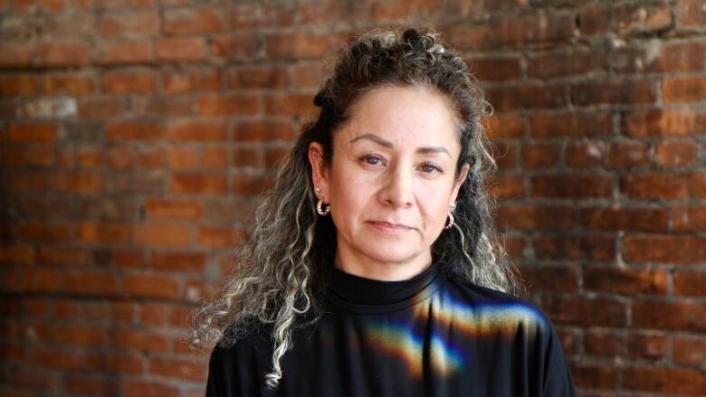 Woman in front of brick wall