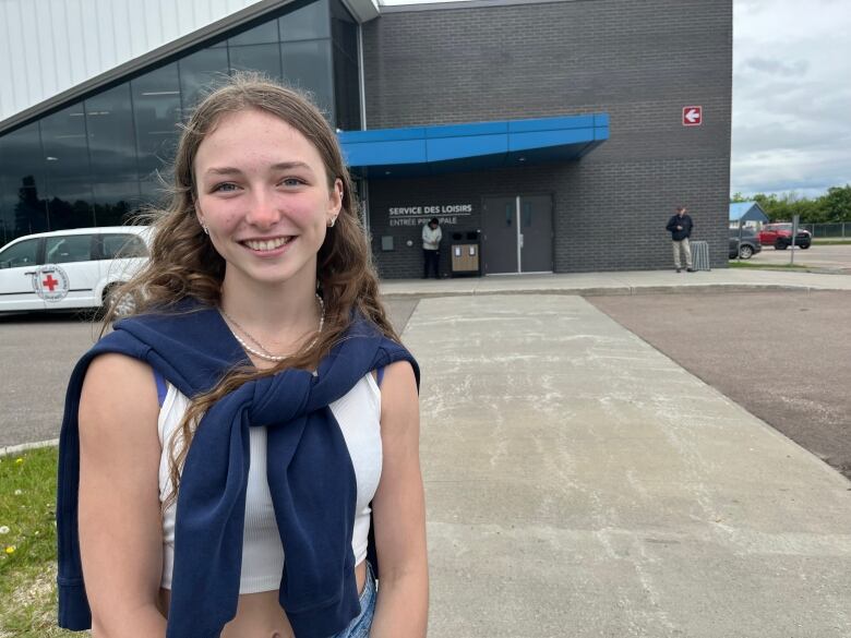 A girl stands in front of a building.