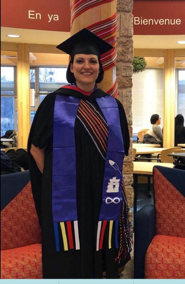 Laura wears her convocation robes and a Metis sash.