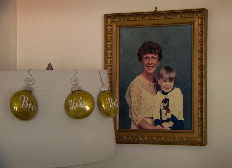 An old picture of a mother and her young son hangs on the wall.